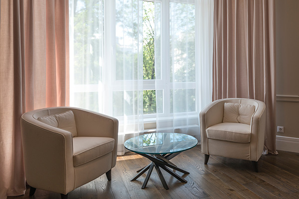 Pastel pink and sheer curtains in seating area