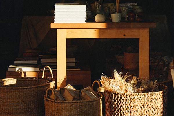 Three wicker baskets under natural wooden table