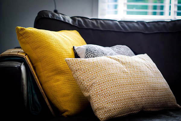 Yellow and patterned cushions on sofa