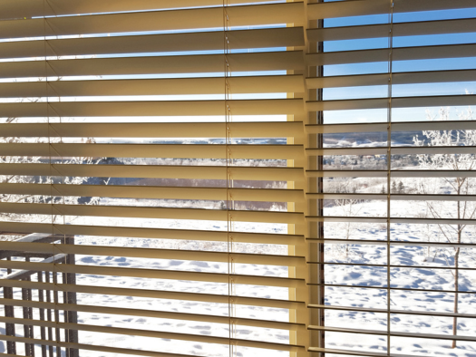 white window blinds looking out to snowy environment